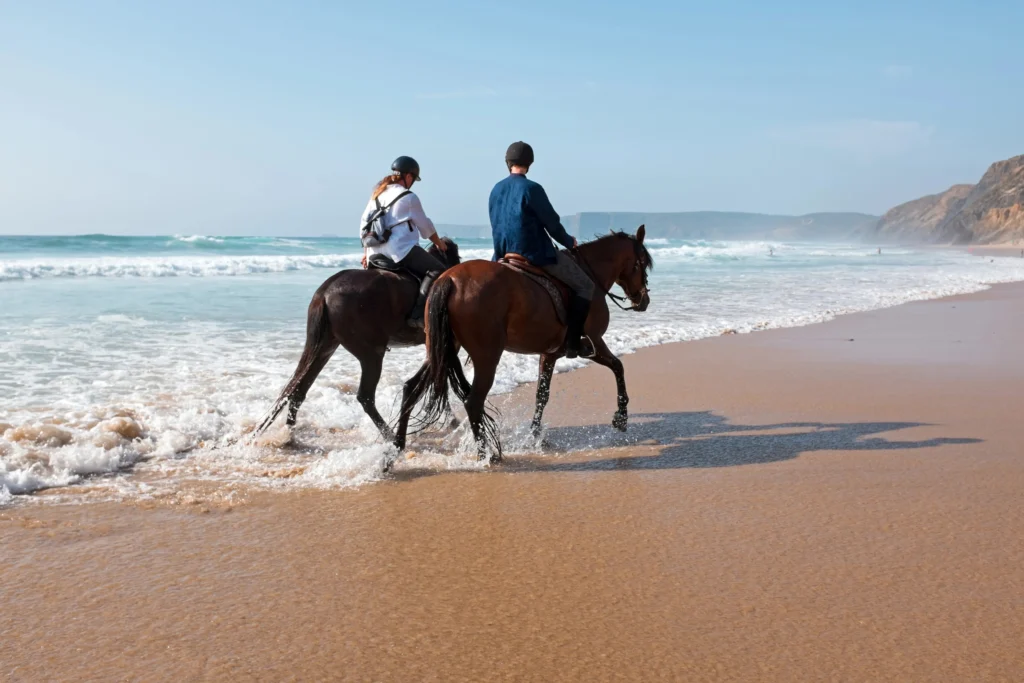 Couple horseback riding on the beach during their Amelia Island honeymoon itinerary