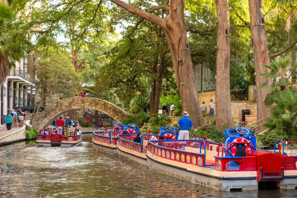 San Antonio River Walk with sightseeing boats and stone bridge